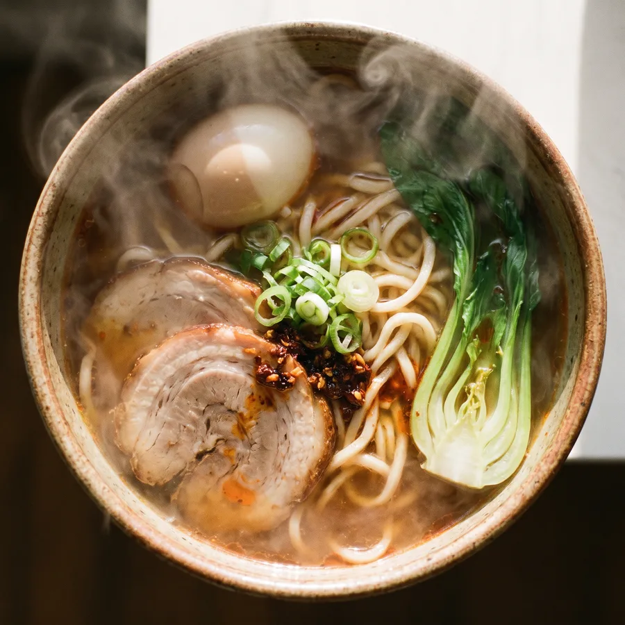 一碗热汤面,俯拍视角,蒸汽升腾,暖色调美食摄影,